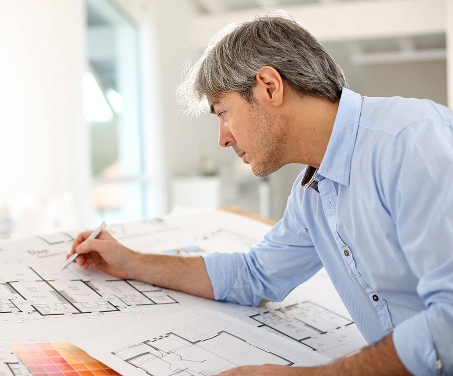 Mies suunnittelee pöytänsä ääressä